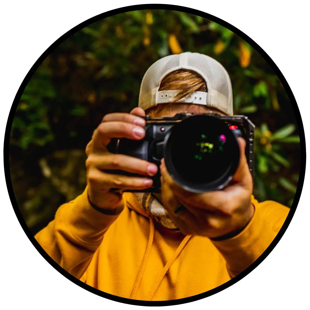 man in yellow hoodie holding digital camera up to camera for nuebo partner program