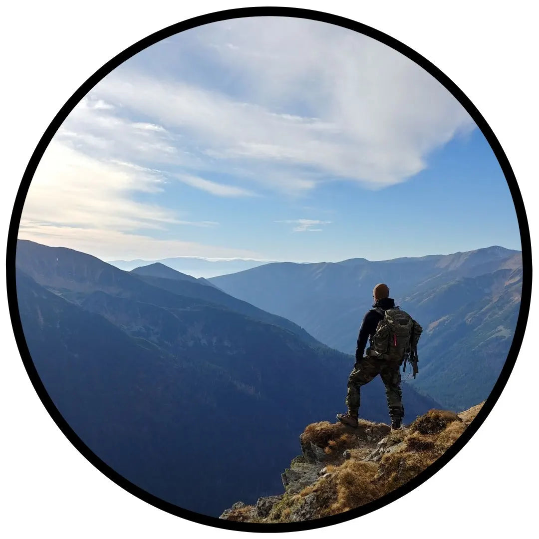 man on top of mountain looking into distance of more mountains partnered with mens accessory brand nuebo